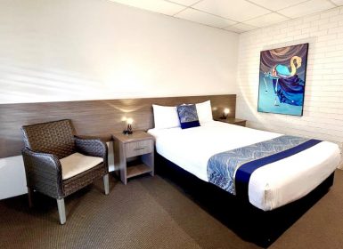 Queen Room With TV On And Visible Bathroom Entrance — Chalet Motor Inn In Bundaberg West, QLD Queen Room With TV On And Visible Bathroom Entrance — Chalet Motor Inn In Bundaberg West, QLD