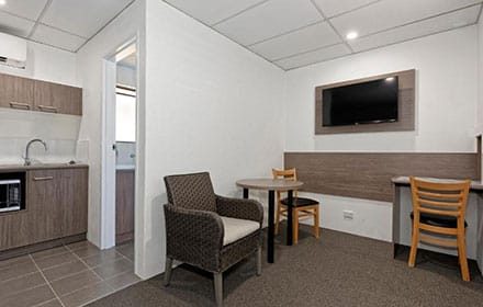 Twin Room With Two Beds, TV, And A Bedside Table — Chalet Motor Inn In Bundaberg West, QLD Twin Room With Two Beds, TV, And A Bedside Table — Chalet Motor Inn In Bundaberg West, QLD